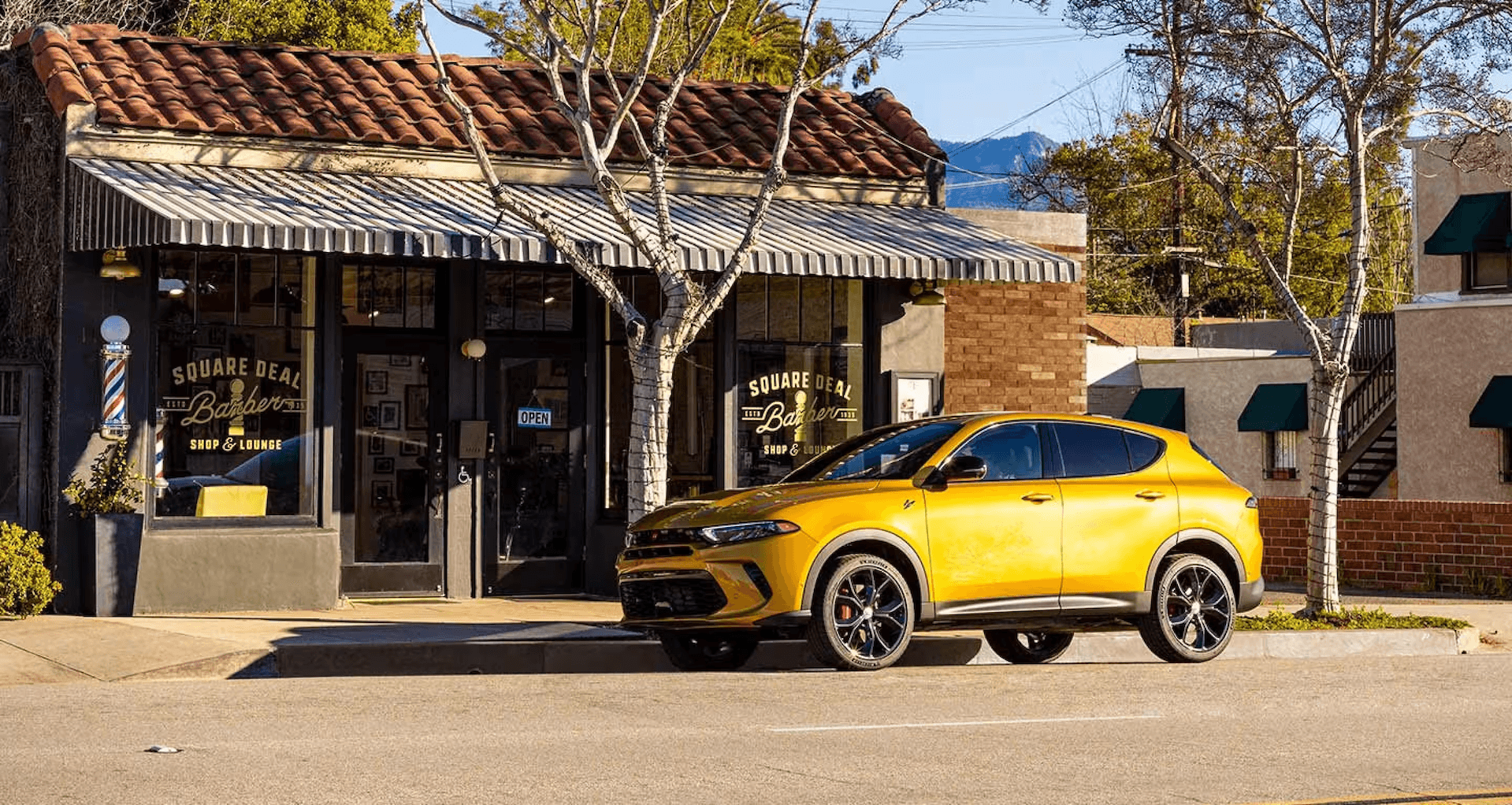 2024 Dodge Hornet parked in front of barbershop