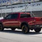 A red 2026 Ram 1500 pickup truck driving on a racetrack