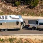 Silver Dodge Ram 1500 pulling a silver camper