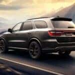 Dodge Durango on road that is in the mountains during the day.