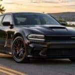 Black Dodge Charger on road in new england setting