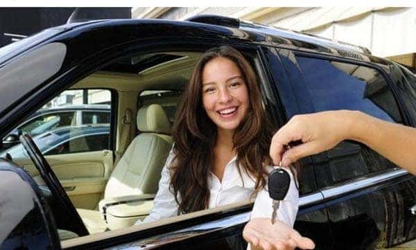 smiling woman receives car keys