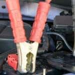 Close up of jumper cables attached to a car battery