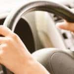 Wheel of car from hand of driver.