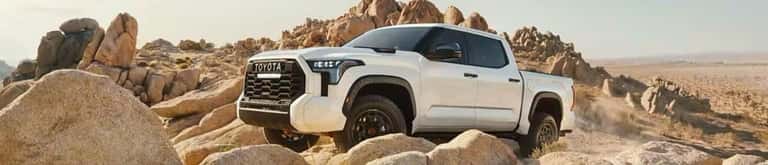 Toyota Tundra in white parked at the top of a hill in the desert