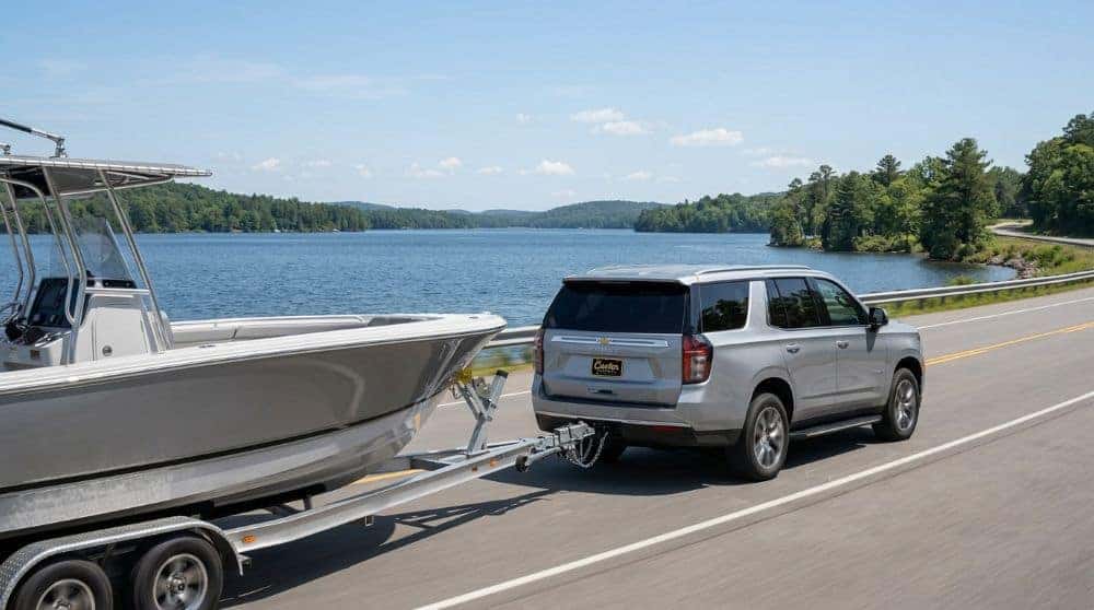 Chevrolet Tahoe in silver towing a boat on a trailer along an Oklahoma lakeside highway
