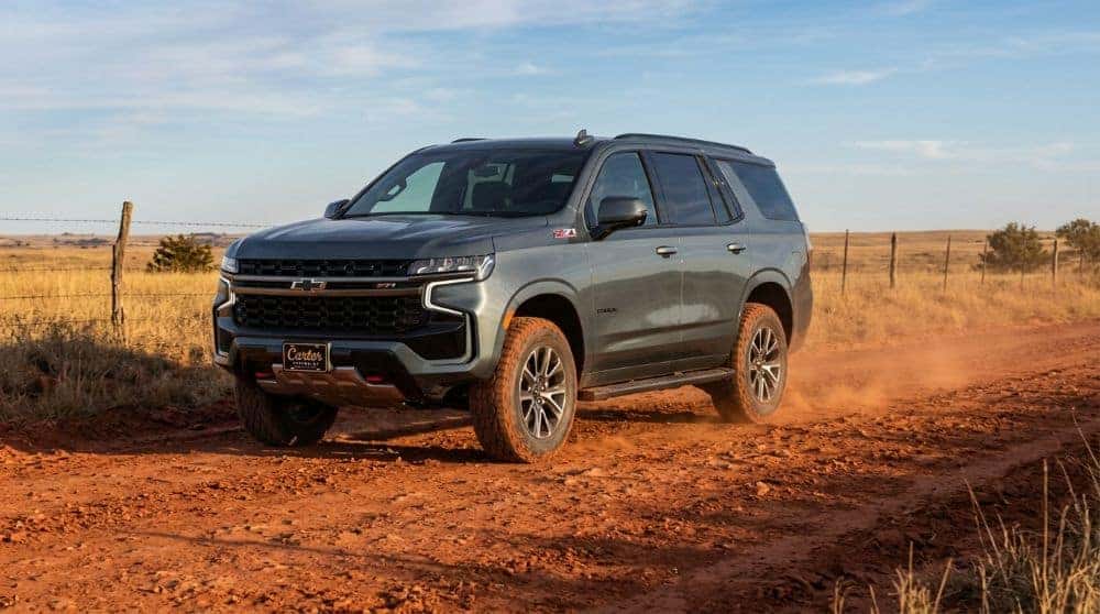 Chevrolet Tahoe Z71 in dark gray on a red-dirt Oklahoma section-line road with all-terrain tires