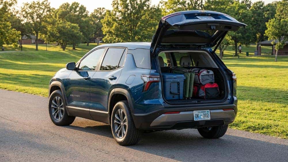 Open rear cargo area of the 2027 Chevrolet Equinox loaded with family gear