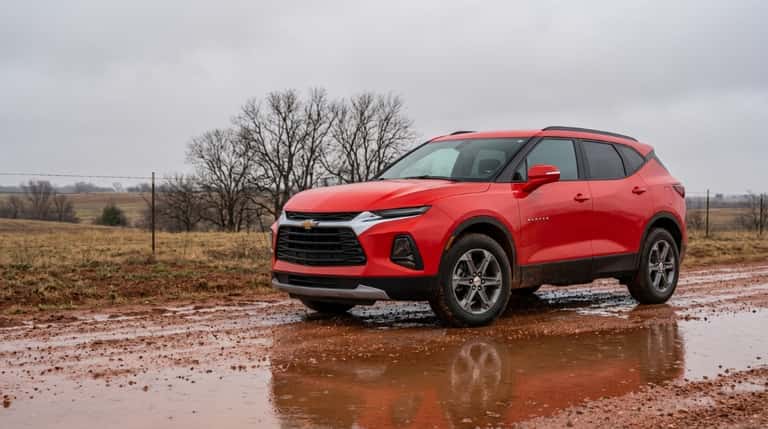 Red Chevrolet Blazer on a wet gravel county road in rural Oklahoma after rain