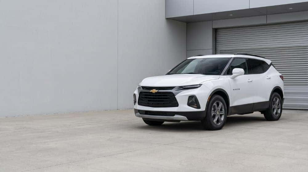 White Chevrolet Blazer parked outside an automotive service entrance in even daylight