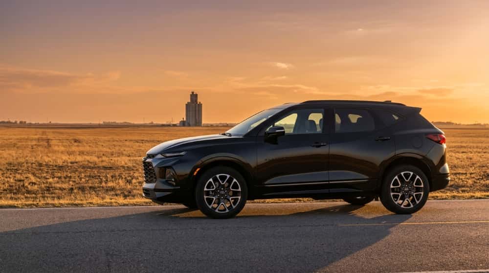 Black Chevrolet Blazer RS in side profile on a two-lane Oklahoma highway near Okarche at golden hour