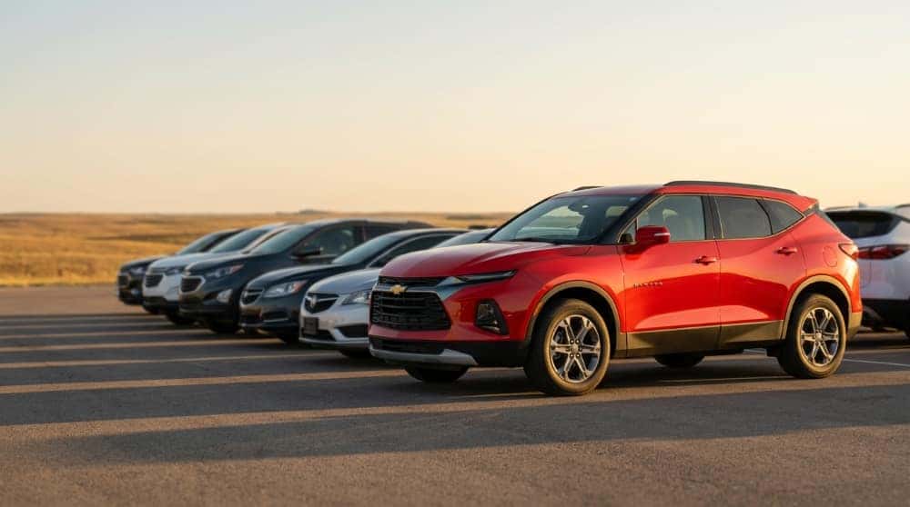 Red Chevrolet Blazer at the end of a row on a rural Oklahoma dealership lot at golden hour