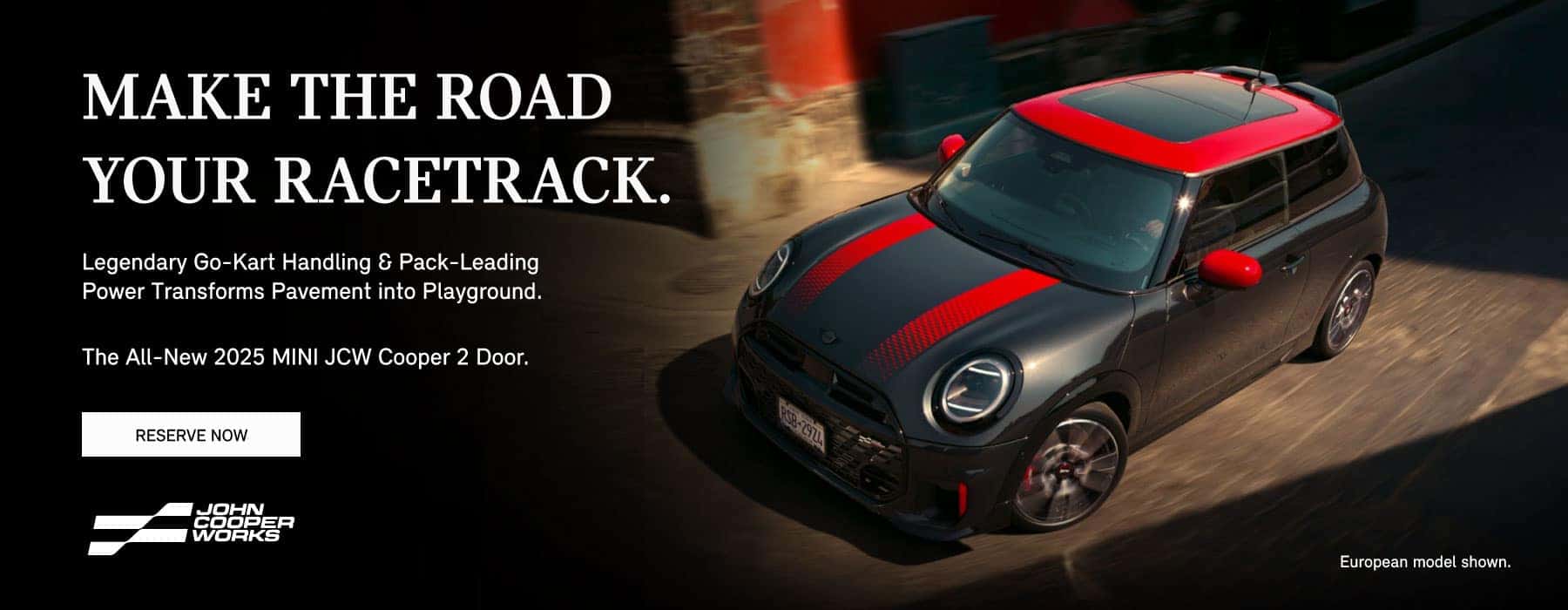 ¾ ariel view of a black MINI Cooper 2 Door with red stripes on a city street.