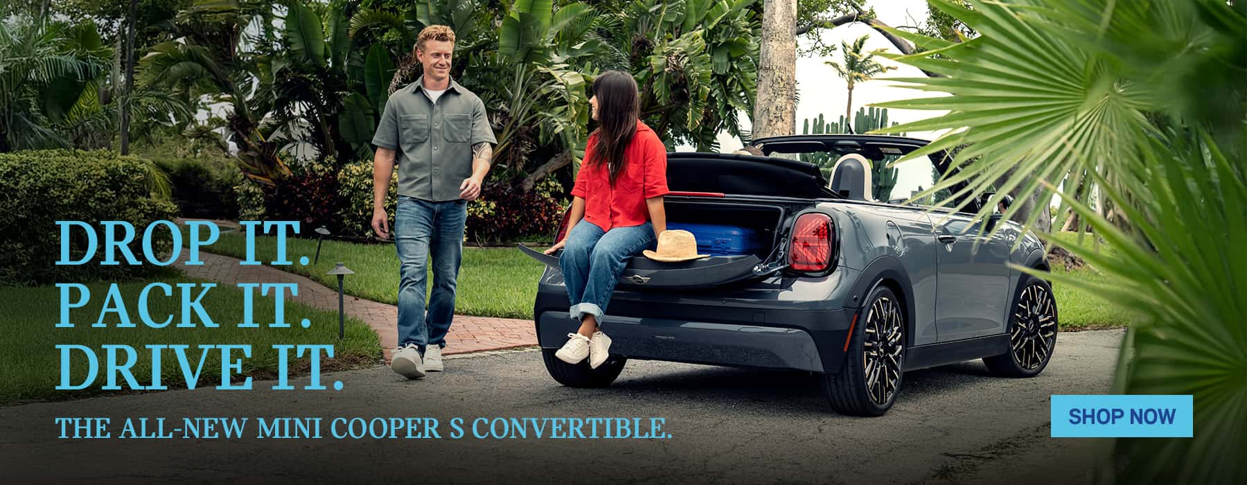 Rear view of grey MINI convertible with woman sitting on the back.