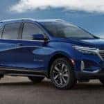 A blue 2022 Chevy Equinox is shown from the side parked under a blue sky after looking at Chevy lease deals.
