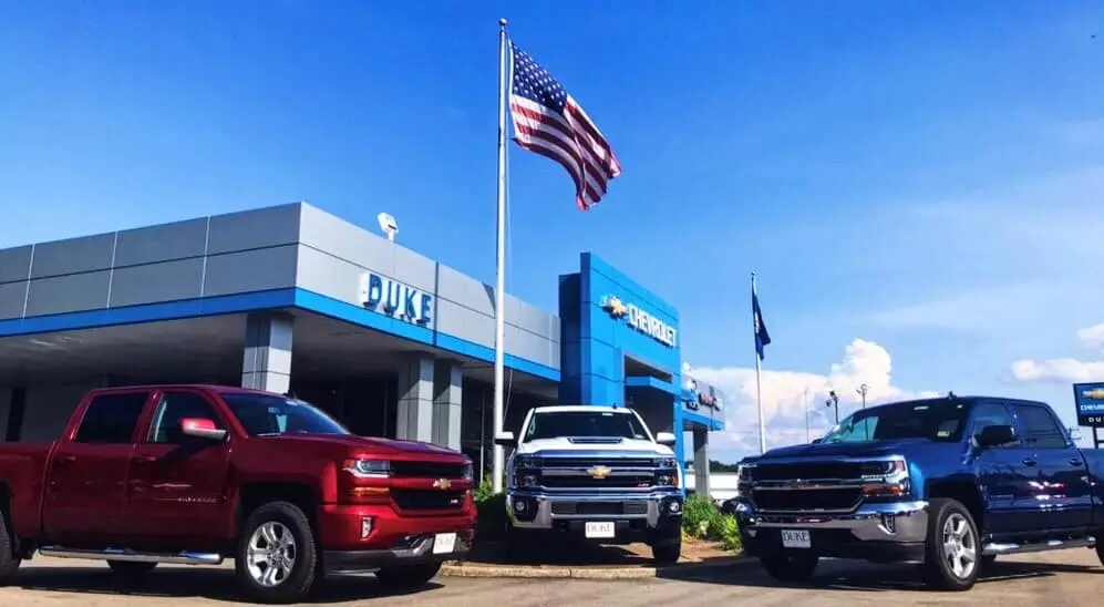 Cars parked outside with view of entrance at the dealership.