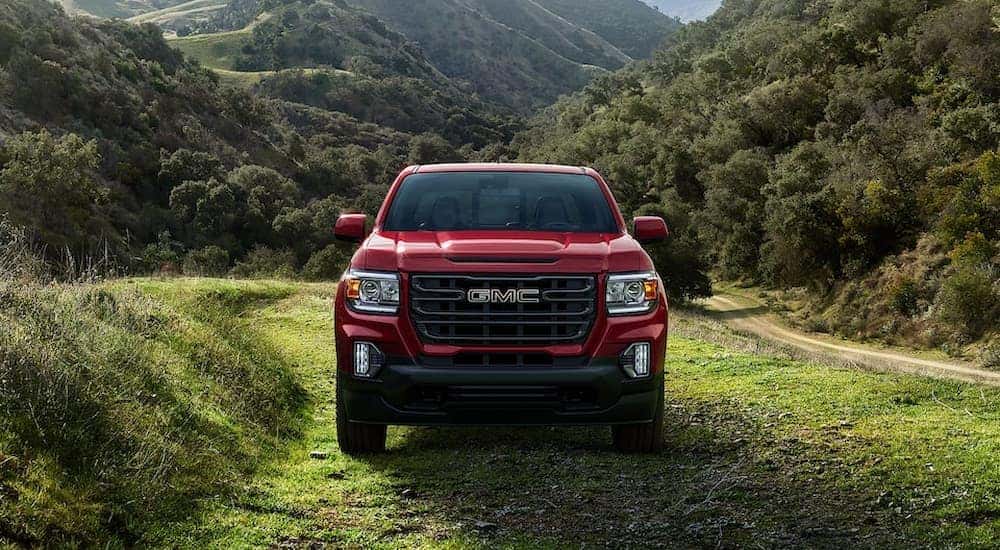 A red 2022 GMC Canyon Elevation is shown parked in a grassy field.
