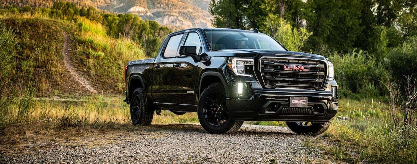 A black 2020 used GMC Sierra 1500 Elevation for sale is shown parked on a rocky path.