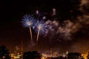 Blue colored fireworks going off and lighting up the night sky.