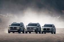 Three dark Honda TrailSport SUVs parked outdoors against a natural, dusty background.