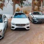 Four Mercedes-Benz E-Class models lined up along road