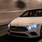White A-Class Sedan driving through tunnel at night
