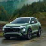 2025 Chevrolet Equinox front three-quarter view driving through a scenic mountain road