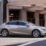 Certified Pre-Owned Chevrolet sedan parked in front of modern building