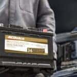 Chevrolet technician holding an ACDelco battery ready for replacement at Greg Hubler Chevrolet Camby IN