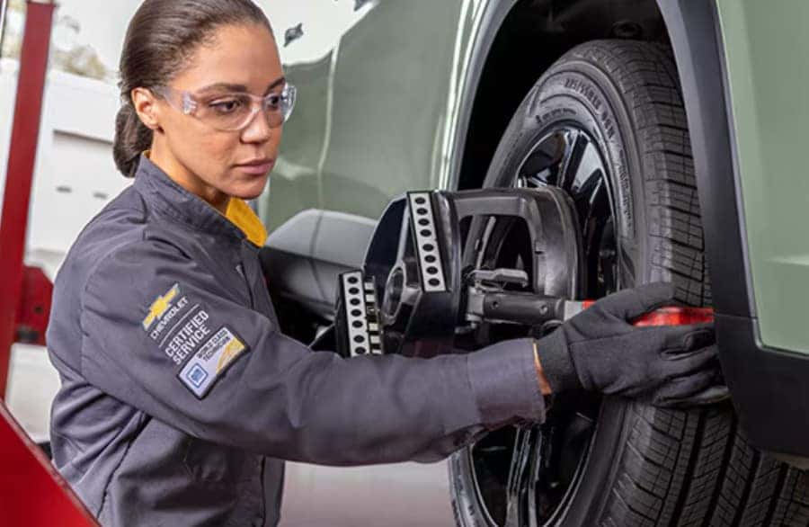 Certified Chevrolet technician checking tire condition and alignment