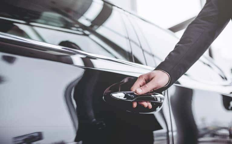 a hand about to open a car door