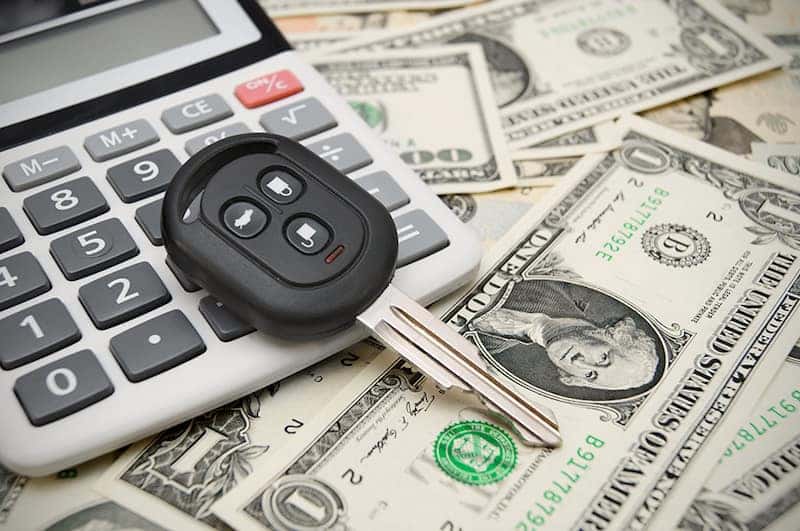 Key from the car and the calculator on money.