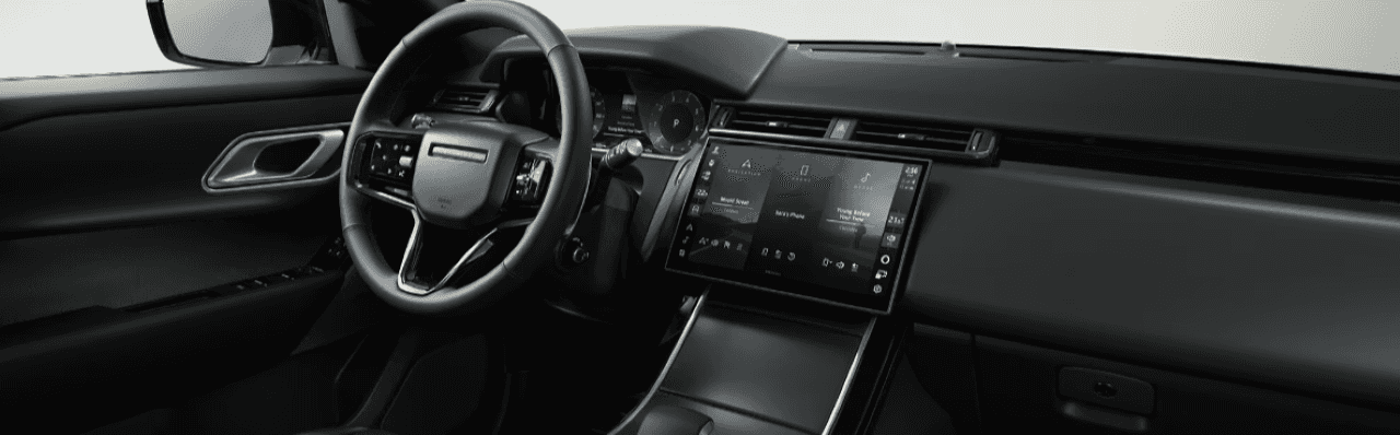 Interior view of the Velar highlighting its luxury leather seating, infotainment system, and panoramic sunroof.