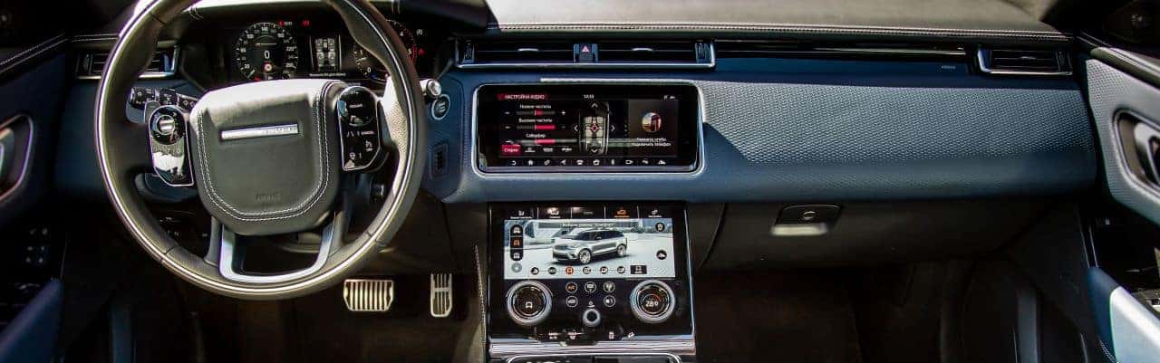 The luxurious interior of a 2020 Velar, featuring premium materials, touchscreen controls, and panoramic roof.