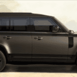 Land Rover Defender 130 parked on dealership lot with three-row seating clearly visible.