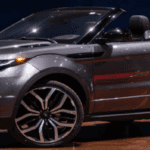 Land Rover Evoque Convertible parked along a scenic Dayton parkway, top down, showcasing its modern design.