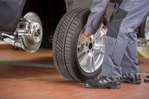 Mechanic Putting Tire on Car