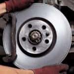 Car mechanic repairing brakes on car banner