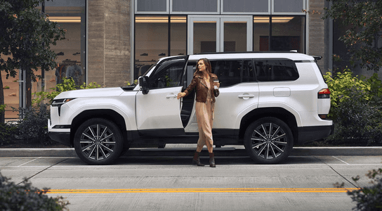 A person exiting the driver's side of the 2024 Lexus GX SUV