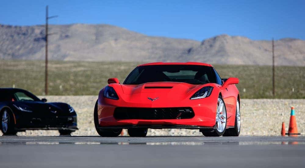 A red 2014 Chevy Corvette is shown from the front driving on a racetrack.
