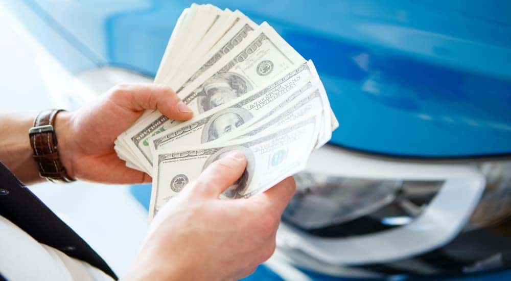 A set of hands is shown holding cash.