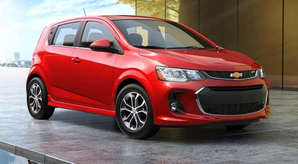 A red 2017 Chevy Sonic is shown from the front parked at a gallery.