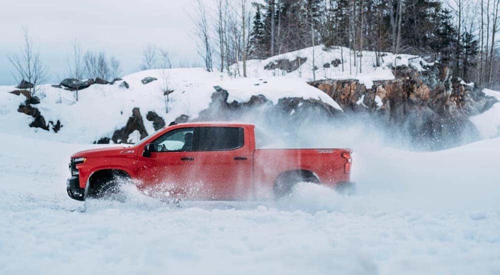 A popular Cincinnati used car, a red 2019 Chevy Silverado TrailBoss, is kicking up snow.