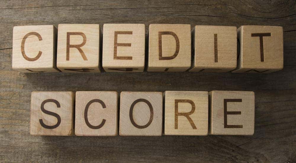 Wooden blocks are shown spelling out credit score.