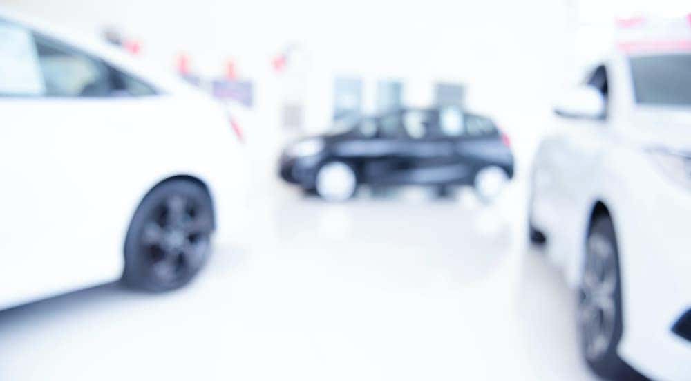 A blurred image shows a Buy Here, Pay Here dealership.