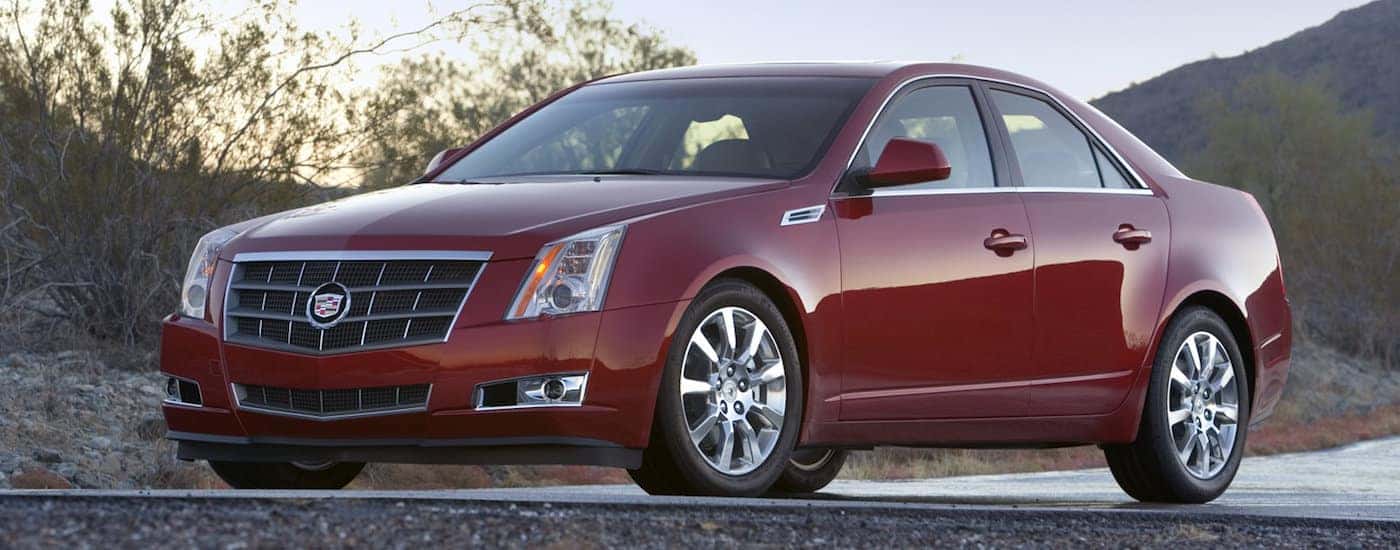 Red 2008 Used Cadillac CTS with mountains in back at dusk