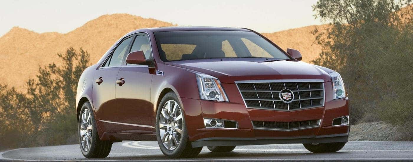 Red 2010 Used Cadillac CTS parked outside with mountains in back