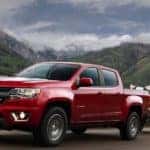 A red Chevy Colorado towing a trailer