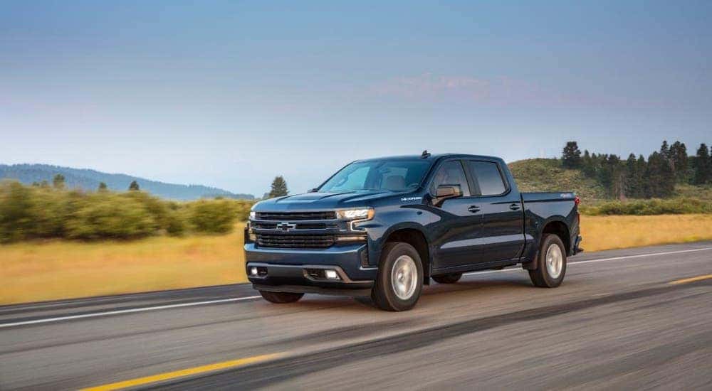 A blue 2020 Chevy Silverado 1500 RST is driving on an empty highway.