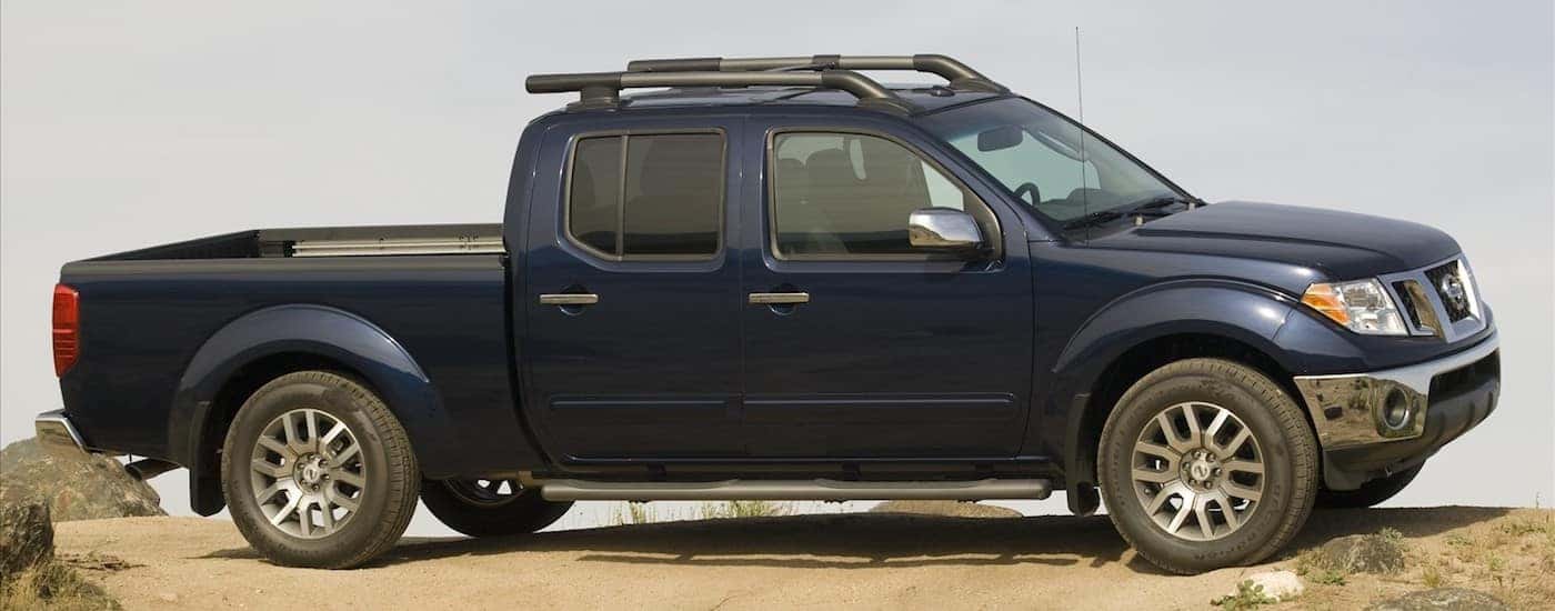 Blue 2010 Used Nissan Frontier on a desert hill